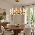 Ravelle 36-inch brass milk-glass chandelier with 12 lights above a round dining table in a sunlit villa
