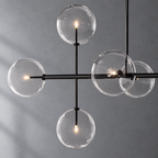 Sierra 72-inch matte black linear chandelier glass globe and metalwork detail on a textured gray background